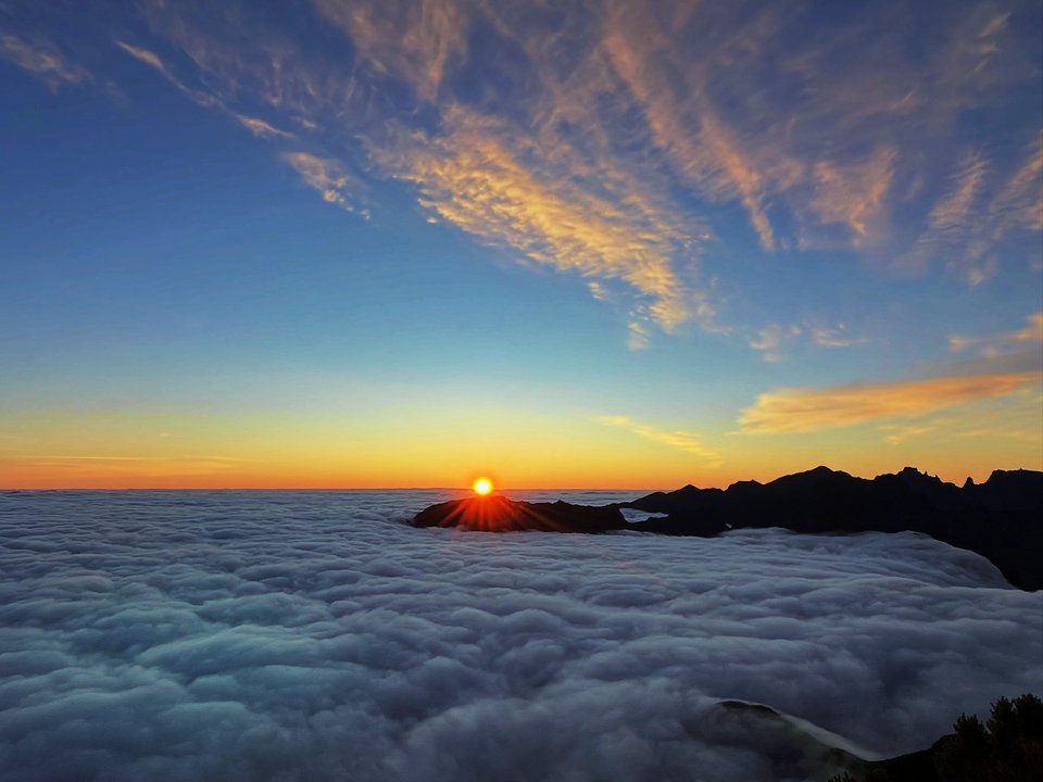 Volcanic rock summit and wind-swept moorland trails at Pico Ruivo do Paul