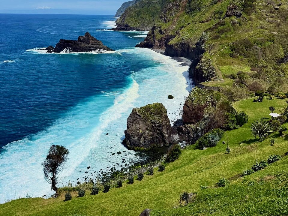 Rugged coastal cliffs and dramatic ocean waves along the northern shore