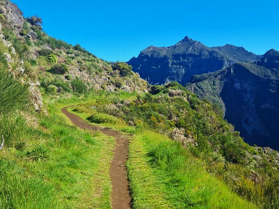 Rugged trail navigating the high volcanic spine and alpine moorlands of Chão dos Terreiros