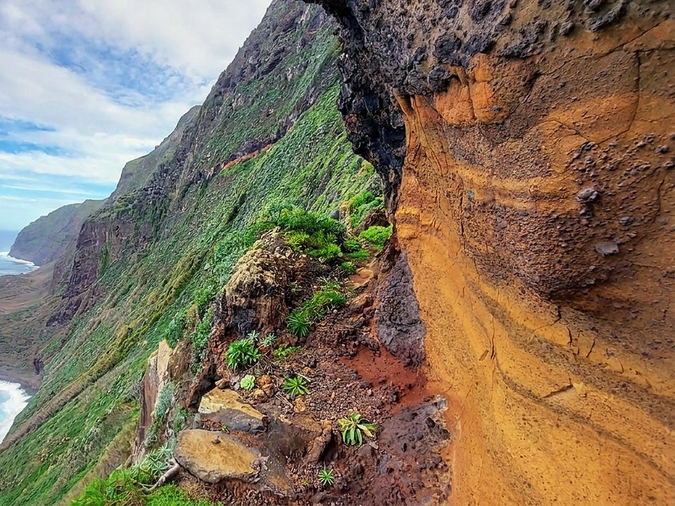 Rock overhang and coastal trail descending toward Fajã da Quebrada Nova