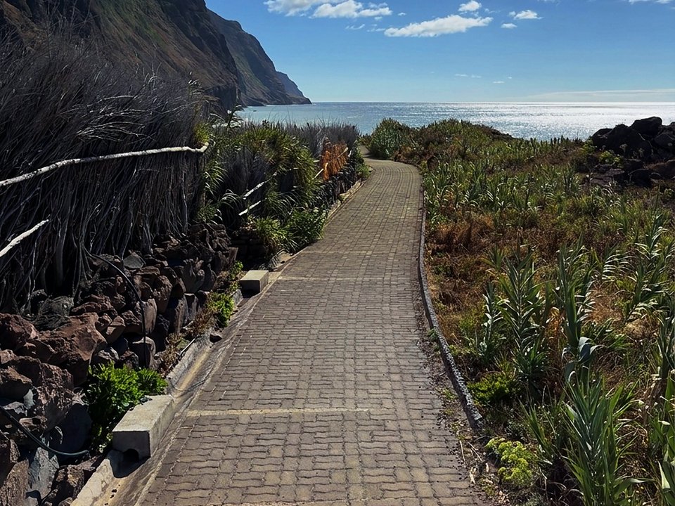 Dramatic ocean cliffs and switchback pathway plunging toward Achadas da Cruz