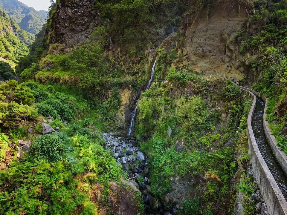 Scenic mountain levada winding above the dramatic valley of Serra de Água