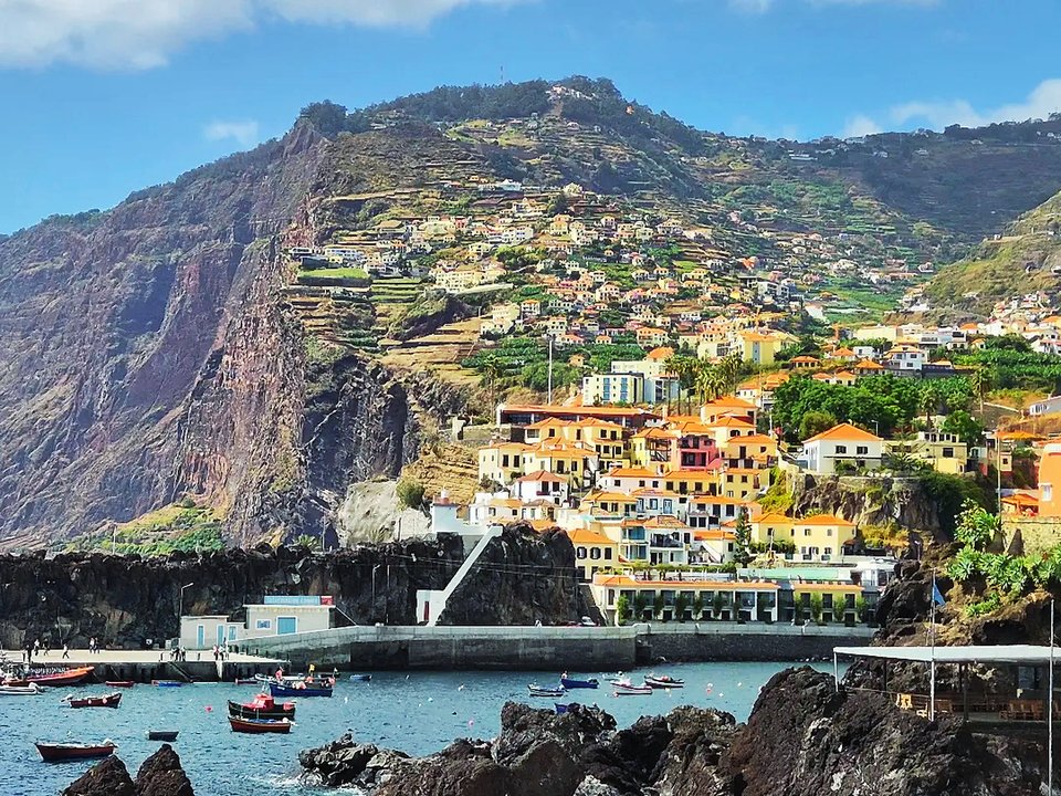 Colorful fishing boats and volcanic bay at the harbor promenade of Câmara de Lobos