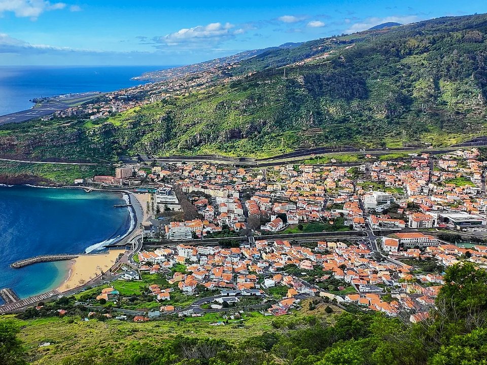 Evening light casting golden hues over the coastal cliffs and bay of Machico