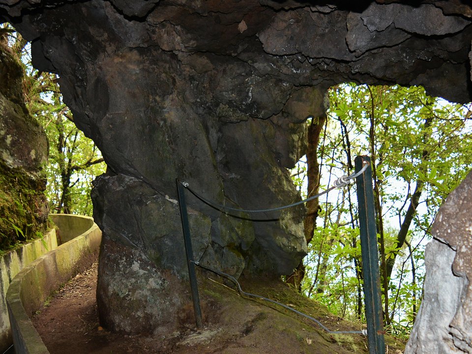 Rock-cut arch and concrete channel box along the cliffside section above Ribeira da Metade on PR 10