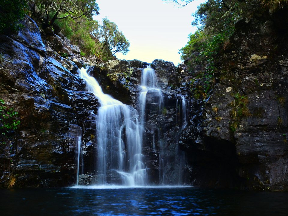 Twin waterfall cascades plunging into the rock pool at Poço da Dona Beja on PR 6.2 Levada do Alecrim