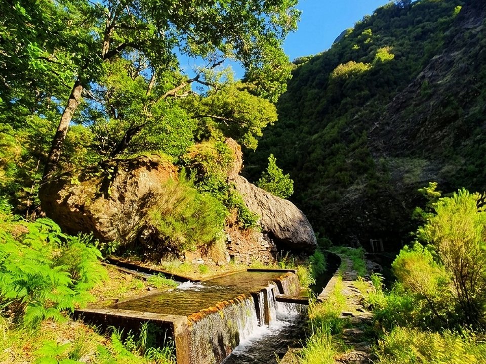 Hydroelectric levada weir and dramatic waterfall cascade in the heart of Fajã da Nogueira