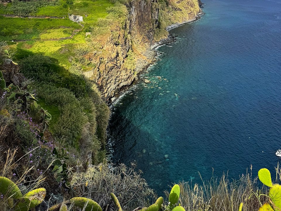 Coastal rock formations and crashing surf seen from the winding cliff staircase
