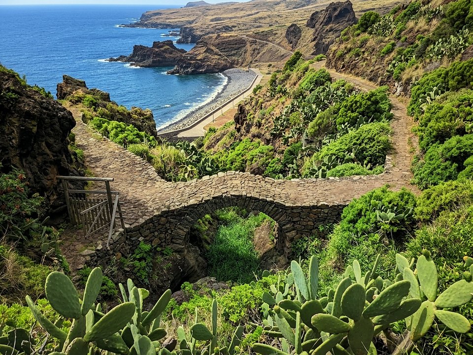 Scenic oceanfront promenade skirting volcanic sea arches along Ribeira do Natal