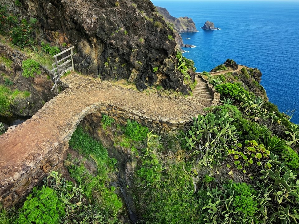Coastal volcanic formations and turquoise Atlantic waters on the Caniçal promenade