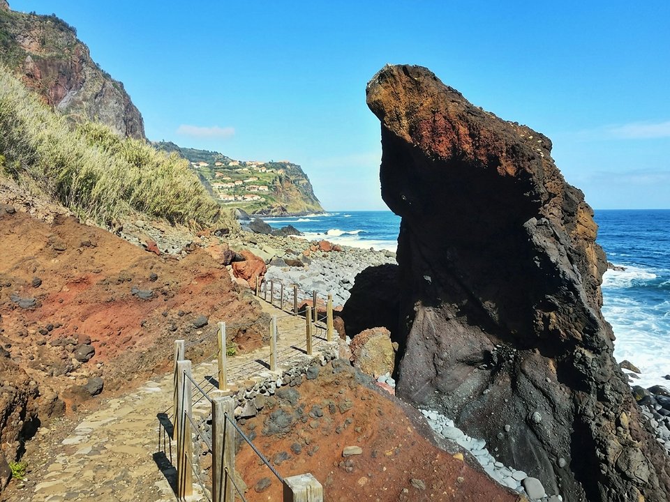 Spectacular steep cliff path plunging toward the Fajã da Rocha do Navio marine reserve
