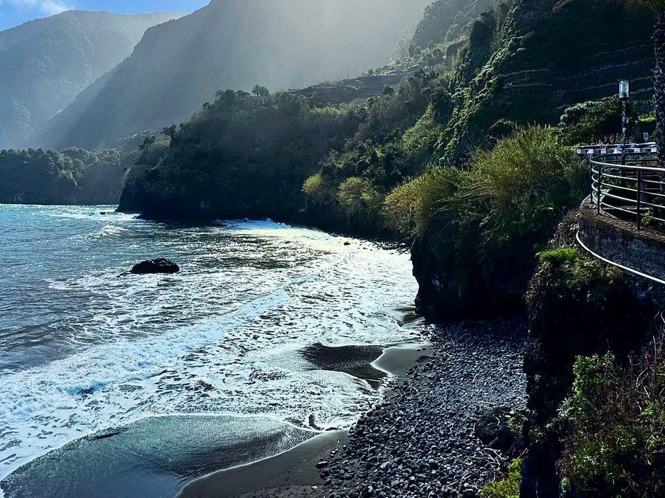 Steep cliff staircase descending to the pebble beach and surf of Calhau