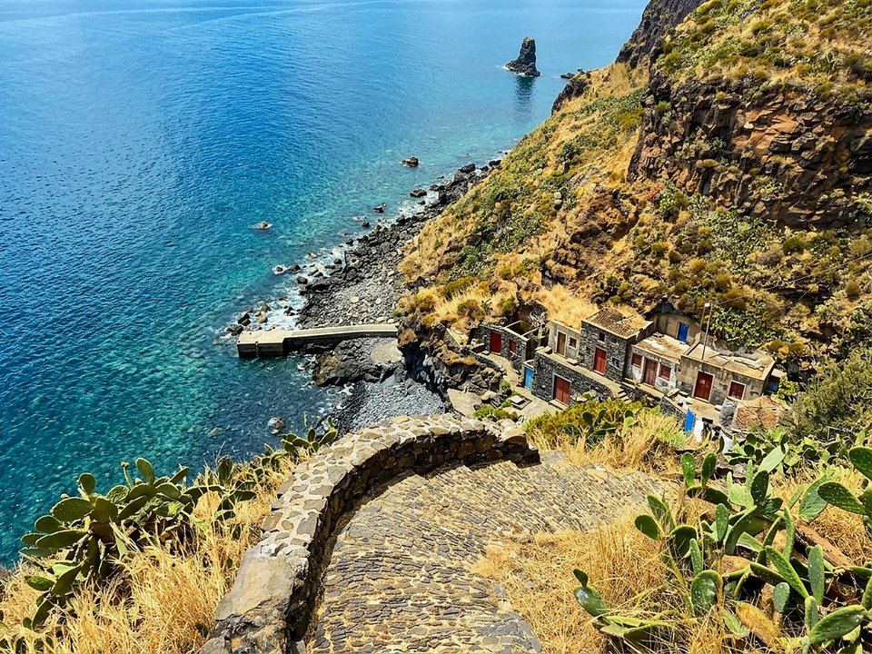 Crystal clear turquoise Atlantic cove and rocky boat ramp at Calhau da Lapa