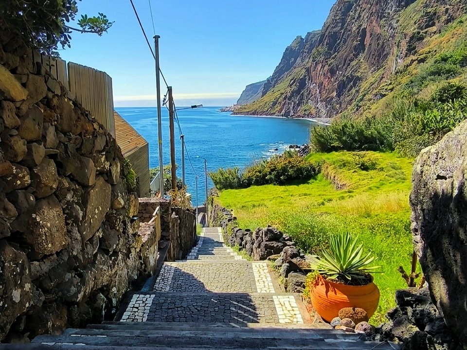 Cobblestoned village trail winding down toward the oceanfront promenade and harbor